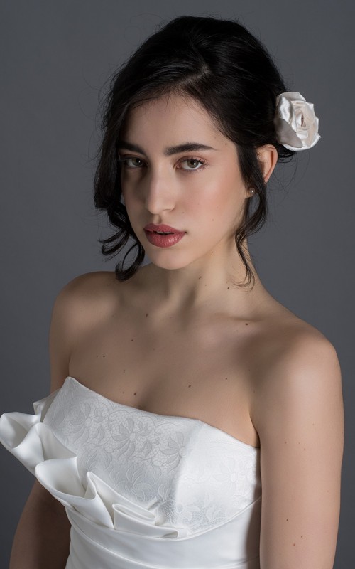 Bride wearing the Letizia strapless ball gown wedding dress in ivory duchess satin with corset lace-up back, handmade in London