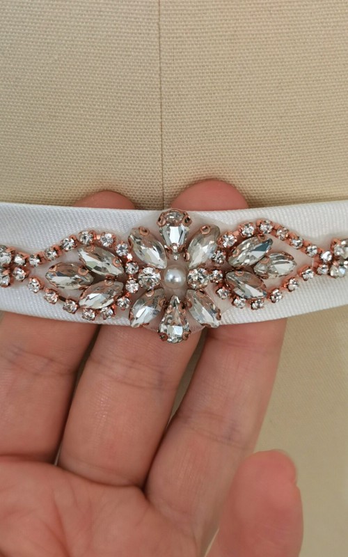 Bridal sash belt with a rose gold crystal and pearl appliqué that ties at the back in a bow