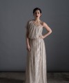 Bride wearing the Lucia one-sleeve vintage-inspired wedding dress in stone lace with pearl and crystal belt, handmade in London