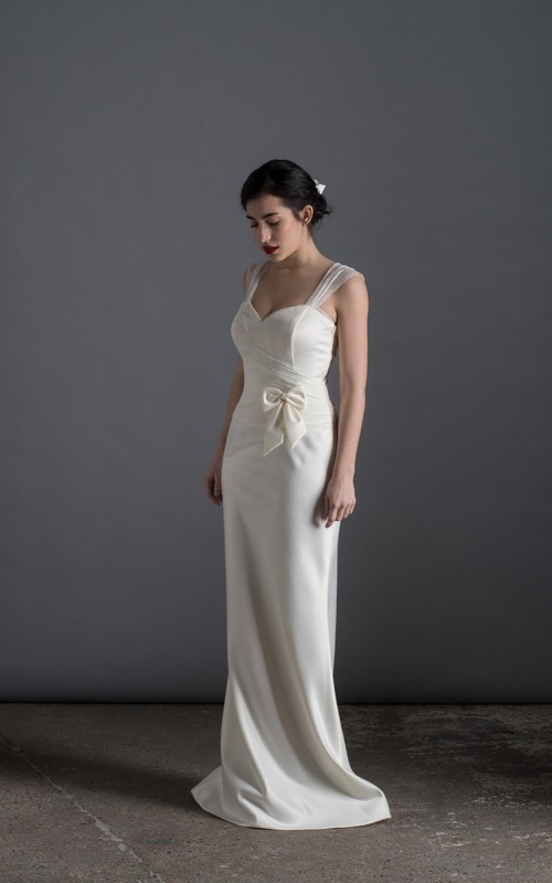 Bride wearing the Lia wedding dress in ivory satin with a detachable tulle overskirt and lace-trimmed train, handmade in London