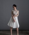 Bride wearing the Luisa two-piece short wedding dress with sheer lace top, 3D floral appliqués and full skirt, handmade in London