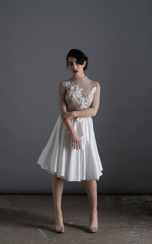 Bride wearing the Luisa two-piece short wedding dress with sheer lace top, 3D floral appliqués and full skirt, handmade in London