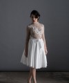 Bride wearing the Luisa two-piece short wedding dress with sheer lace top, 3D floral appliqués and full skirt, handmade in London