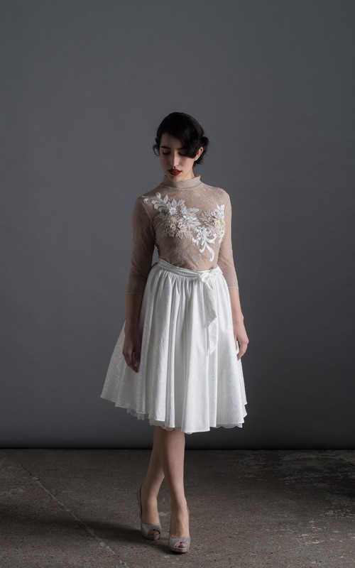 Bride wearing the Luisa two-piece short wedding dress with sheer lace top, 3D floral appliqués and full skirt, handmade in London