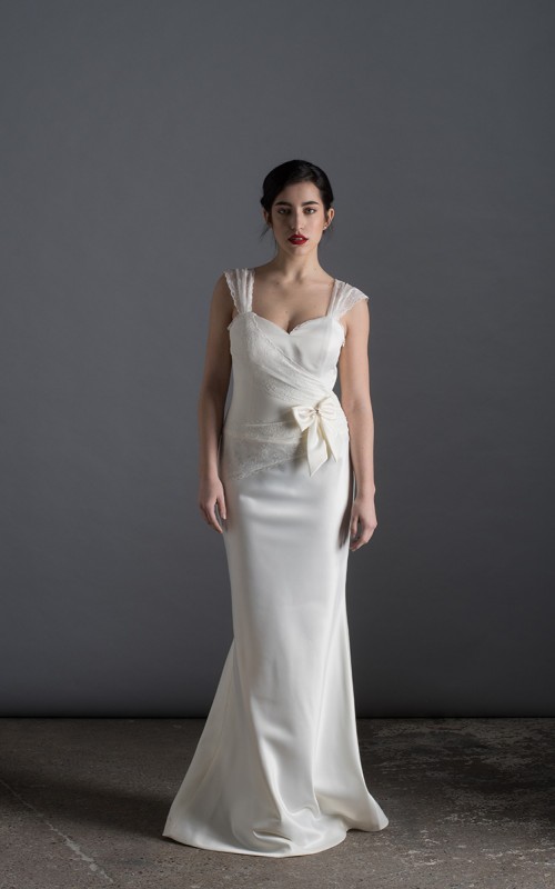 Bride wearing the Lia wedding dress in ivory satin with a detachable tulle overskirt and lace-trimmed train, handmade in London