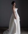 Bride wearing the Letizia strapless ball gown wedding dress in ivory duchess satin with corset lace-up back, handmade in London