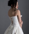 Bride wearing the Letizia strapless ball gown wedding dress in ivory duchess satin with corset lace-up back, handmade in London