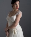 Bride wearing the Lia wedding dress in ivory satin with a detachable tulle overskirt and lace-trimmed train, handmade in London
