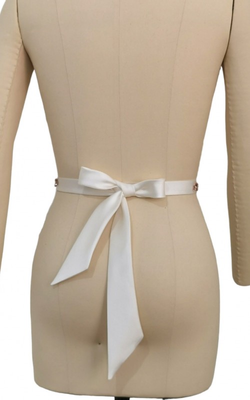 Bridal sash belt with a rose gold crystal and pearl appliqué that ties at the back in a bow