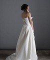 Bride wearing the Letizia strapless ball gown wedding dress in ivory duchess satin with corset lace-up back, handmade in London