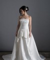 Bride wearing the Letizia strapless ball gown wedding dress in ivory duchess satin with corset lace-up back, handmade in London