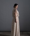 Bride wearing the Lucia one-sleeve vintage-inspired wedding dress in stone lace with pearl and crystal belt, handmade in London