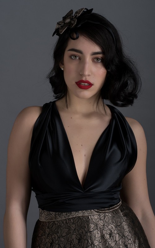 Valeria short halter cocktail dress with deep V-neck black satin bodice, open back and black and beige pleated jacquard skirt